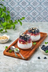 Chia pudding with nut granola, honeysuckle berry puree and whole honeysuckle  berries in...