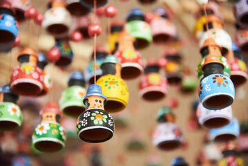 Sale of ceramic handicrafts in Raquira, Boyaca, Colombia: decorative hanging ornaments painted with colorful designs. Composition with copy space and selective focus.