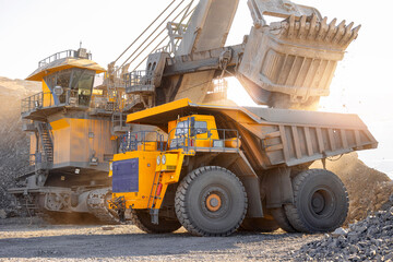 Heavy machinery in open pit coal mine during, large yellow trucks and excavators