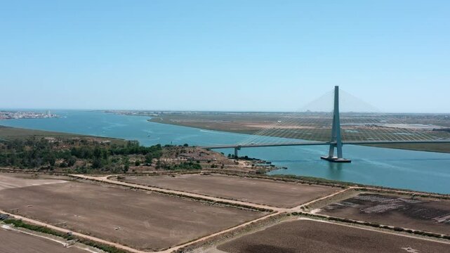Beautiful aerial view of the international bridge over the guadiana river, connecting ayamonte, spain, and castro marim, portugal, under a clear blue sky