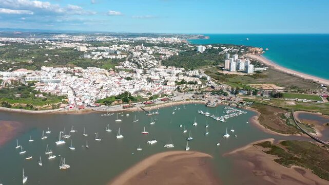 Beautiful aerial view of alvor, portugal, showcasing the ria de alvor estuary, the atlantic ocean, the marina, white buildings, and green vegetation. Aerial view praia de Alvor