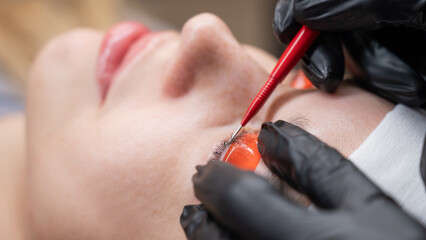 Caucasian woman undergoing eyelash lamination procedure. 