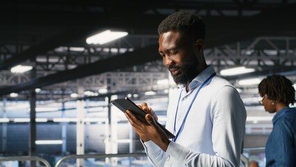 Software developers on data center industrial platform analyzing performance outputs on devices. Server room IT specialists collaborating on finetuning mainframes configurations