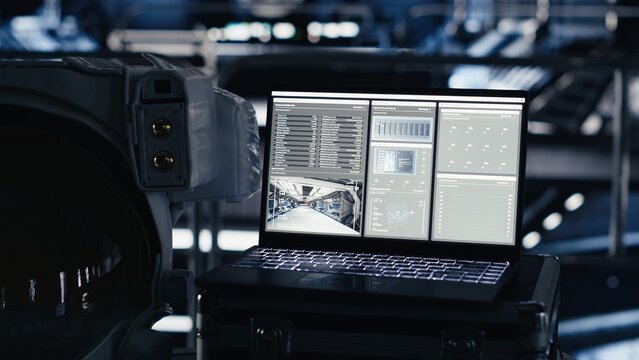 Laptop inside high tech spaceship cockpit displaying analytics and mission telemetry software. Notebook in orbit station shows performance dashboard during cosmic navigation
