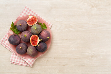 Fresh tasty fig fruits on wooden background, top view
