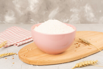 Bowl with spelt flour on concrete background
