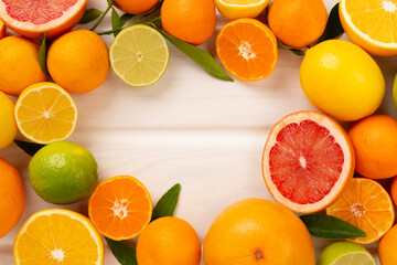Different citrus fruits on wooden background, top view