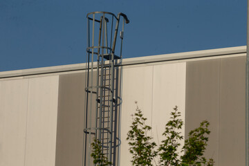 A sturdy ladder is securely attached to the outer side of a tall and expansive building, providing...