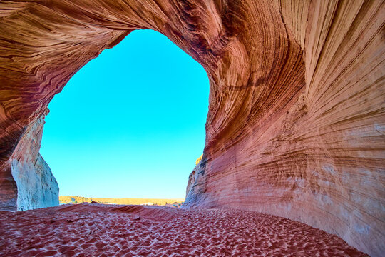 Sandstone Cave Arch with Striated Rock and Blue Sky Upward Motion Perspective