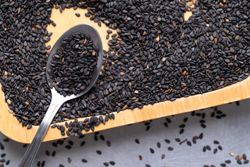 Black sesame seed in spoon and wooden plate, Healthy eating, Top view