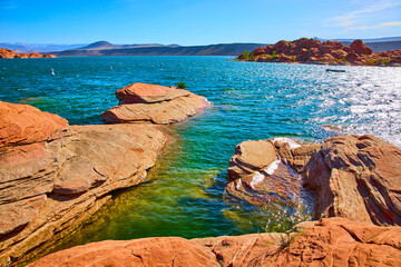 Red Sandstone and Blue Lake Water with Distant Hills Low Angle Lake Edge