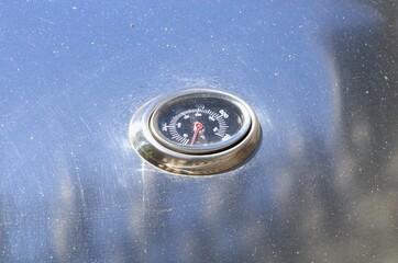 oval thermometer on steel grill