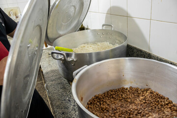 Large pots of cooked rice and beans, staple Brazilian cuisine. Illustrates meal preparation in bulk...
