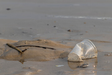 Plastic cup thrown like garbage on the sand of the  beach in Brazil