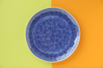 Empty plate on color background, top view