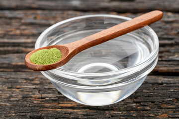 Bowl of water and a spoonful of moringa powder - Moringa oleifera