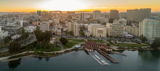 Obraz premium Aerial view of Oakland, California, USA, at sunset. The photo shows the city skyline, Lake Merritt, and the boathouse. The image captures the beauty of the city and its waterfront.