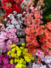 Colorful assortment of artificial flowers displayed at a market