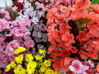 Colorful assortment of artificial flowers in various shades and types at a market stall