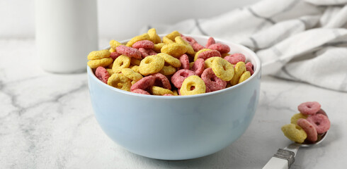 Bowl with tasty cereal rings on light table