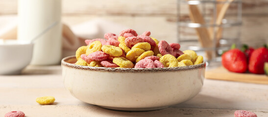 Bowl with tasty cereal rings on light table