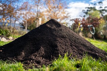 turning a compost pile in a community garden. compost full of microorganisms. sustainable regenerative agriculture