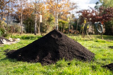 turning a compost pile in a community garden. compost full of microorganisms. sustainable regenerative agriculture