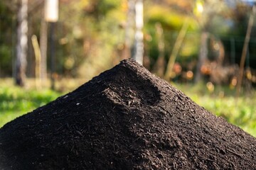 turning a compost pile in a community garden. compost full of microorganisms. sustainable regenerative agriculture