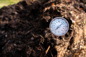 measuring the temperature of a Compost pile, organic thermophilic compost turning in Tasmania Australia on a farm