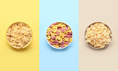 Set of bowls with tasty breakfast cereals on color background, top view