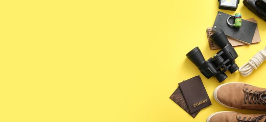 Set of traveler's accessories on yellow background with space for text