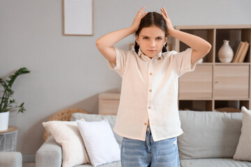 Cute girl suffering from headache at home