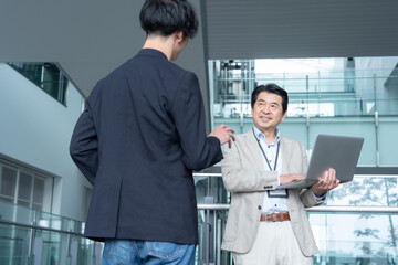 Fototapeta premium オフィスで打ち合わせをするエンジニア 撮影協力：スカパー東京メディアセンター