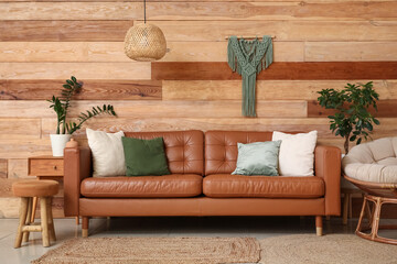 Comfortable sofa, armchair and pouf in interior of living room