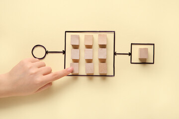 Female hand with wooden cubes and flowchart on yellow background. Logic concept
