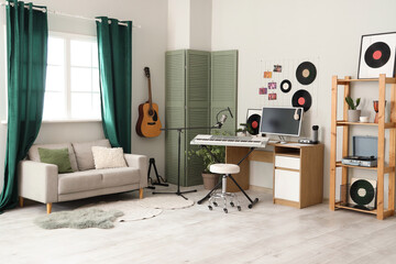 Interior of recording studio with workplace, musical instruments and sofa