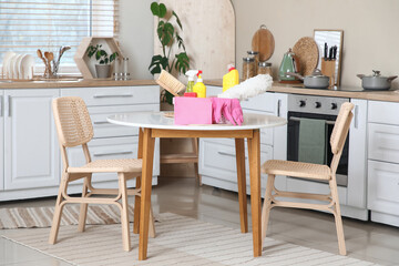 Basket of cleaning supplies and pp-duster on table in kitchen