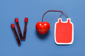 Paper blood pack with red heart and test tubes on blue background. Blood donation concept