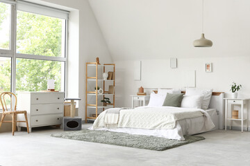 Interior of bedroom with big bed, scratching post for cats, shelving unit and home decor on white...
