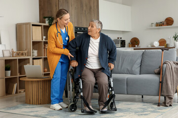 Young caregiver and senior woman sitting in wheelchair at home