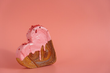 Heart shaped strawberry berry croissant on pink background with copy space. Puff pastry new trendy...