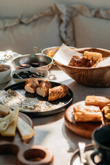 Traditional Turkish breakfast table with bread, cheese, olives and spreads in natural morning light