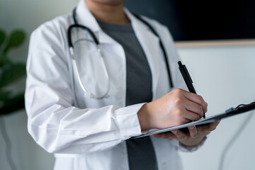 Doctor or nurse standing with clipboard and pen, writing patient notes or treatment plans, symbolizing clinical assessment, health monitoring, and effective medical documentation.