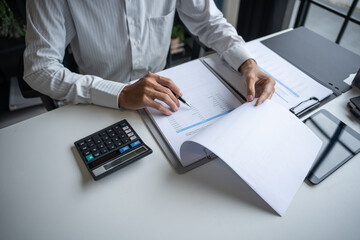 Professional Reviewing Business Data and Using Calculator.