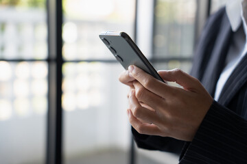 Asian Business woman using smart phone spending time checking news social media