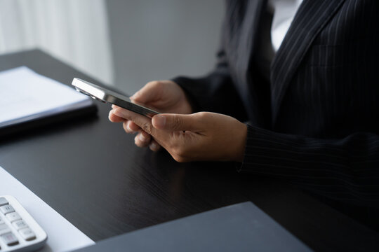 Asian Business woman using smart phone spending time checking news social media