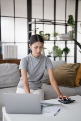 Asian Woman Pressing calculator for
 financial planner remotely Personal finance at home.