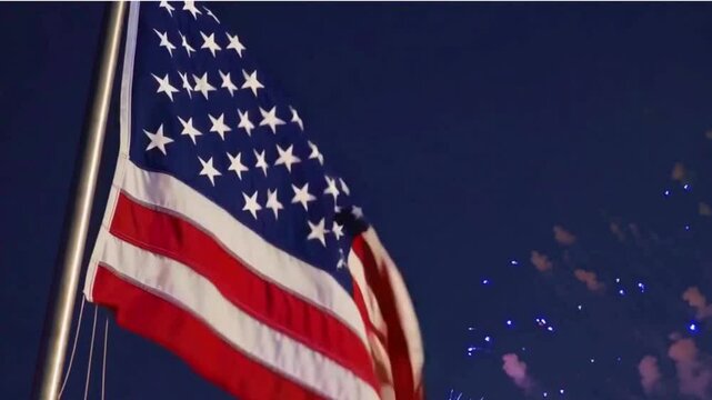 4K Video of a July 4th Celebration With an American Flag Waving and Fireworks in the Background