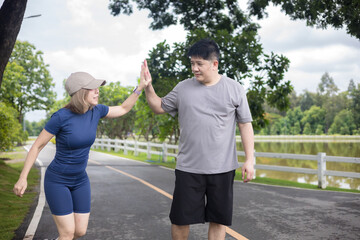 Woman and a man are giving each other high fives after finishing a run