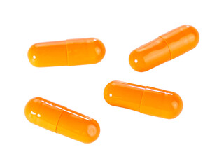 Bulk orange capsule pills isolated on white background.